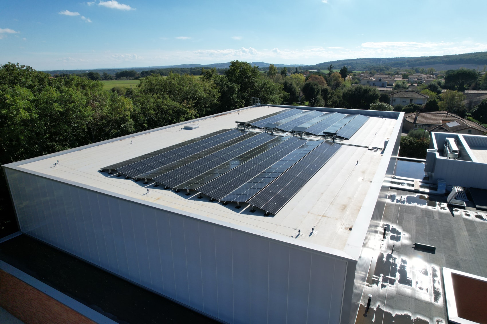 Couverture solaire en surimposition sur la toiture du nouveau gymnase